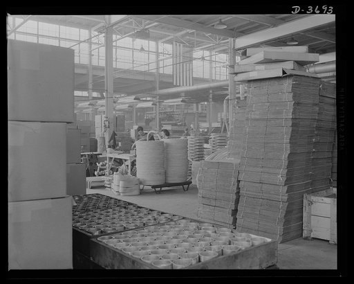 Sand castings ready to be used in producing aluninum articles for Uncle Sam's Army and Navy. The folded corrugated boxes piled up are made from waste paper. Aluninum Industries