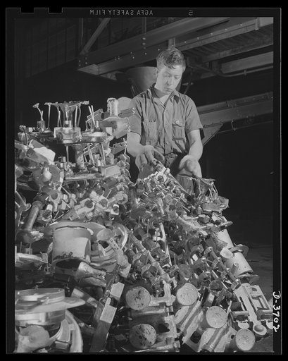 Inspection of rough sand castings. Destined for use by a branch of America's armed forces, more than half of this casting will be cut away, remelted and recast. Aluminum Industries