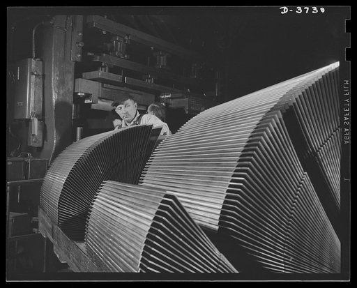 The jeeps are coming. Great stacks of hood tops are stamped out by a 100-ton Hamilton press in a plant that used to produce thousands of automobiles daily. The plant is working on an even faster pace now on war production. Ford Lincoln plant, Michigan