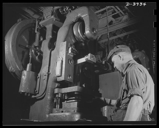 Pounding away at the Axis. A Fericute press and operator who used to work on the making of high-priced autombiles stamp out great quantities of small parts for army "jeeps," now being assembled in various parts of the country. Ford Lincoln plant, Michigan