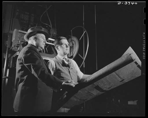 Planning for heavy war production. A department foreman and a tool designer direct the conversion of a big automobile plant to the manufacture of army "jeeps" and trucks. Ford Lincoln plant, Michigan