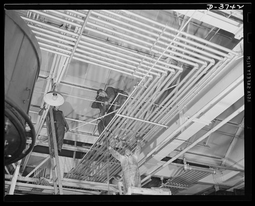 Converting to war production. Steel workers make structural changes as a big auotmoobile plant is entirely changed over to mass production of army tanks and "jeeps." Ford Lincoln plant, Michigan