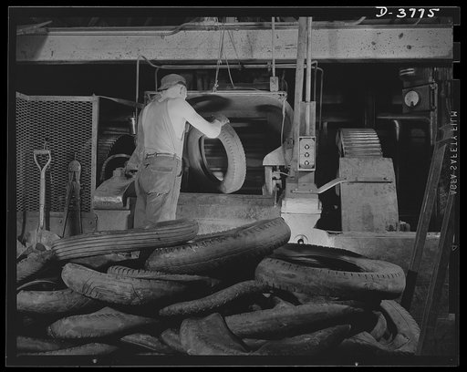 Rubber reclamation. Scrap tires, with beads removed, are fed to the "cracker," or grinding machine, of a big Midwest tire plant. The machine breaks the scrap tire into small pieces to facilitate removal of rubber from fabric. Firestone