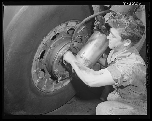 YB-17 bombardment squadron, Langley Field, Virginia. Brakes on the landing gear of a YB-17 bomber. A sergeant of a bombardment squadron at Langley Field, Virginia makes adjustments that will help this big warship  of the air to land smoothly