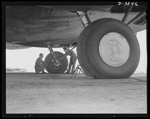 YB-17 bombardment squadron, Langley Field, Virginia. The enormous size of the landing wheels of a YB-17 bomber can be appreciated when compared with the sizes of the two men inspecting the landing gear. The men, a staff sergeant and a technical sergeant, belong to a bombardment squadron at Langley F