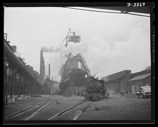 Steel production. Iron production for war industry. There's plenty of activity in the row of boiler house stacks, in the roaring blast furnace and the stock trestle that serves them. Republic, Youngstown