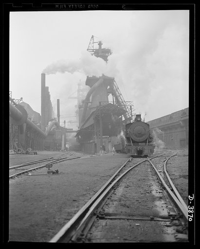 Steel production. Driving hard for iron production. There's plenty of activity in the row of boiler house stacks, in the roaring blast furnaces and the steel trestle that serves them. Republic, Youngstown