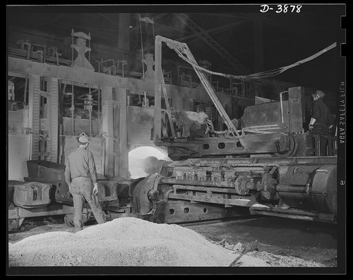Steel production. Scene in steel industry. A charging machine dumps material for making steel into an open hearth furnace at a big Eastern plant. Republic, Youngstown