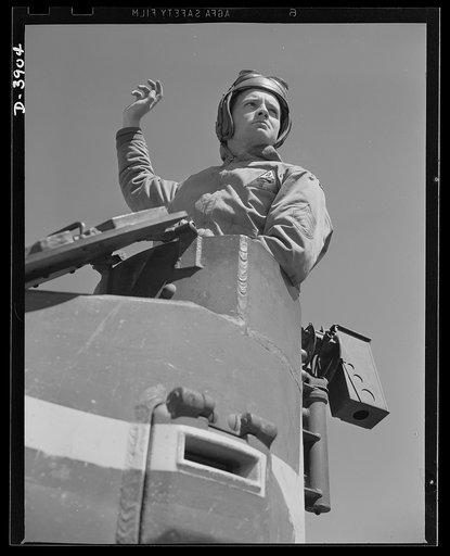 Fort Benning. Tank forces. A sergeant of the armored forces directs student soldiers from an old type, light tank used for training purposes at Fort Benning, Georgia. All trainees finish their courses in up to the minute equipment