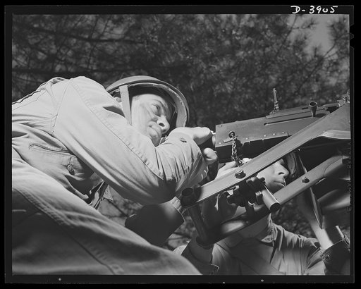 Fort Benning. Halftrac scout cars. He's a good shot, too. A machine gunner on a halftrac scout car gets some target practice as the driver at his left tools the car through the training area at Frot Benning, Georgia