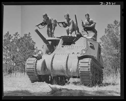 Fort Benning. Tank forces. A medium tank (M-3) bristles with cannon, anti-aircraft guns, Tommy guns and pistols as soldiers of the armored forces in training ar Fort Benning, Georgia prepare for a sally