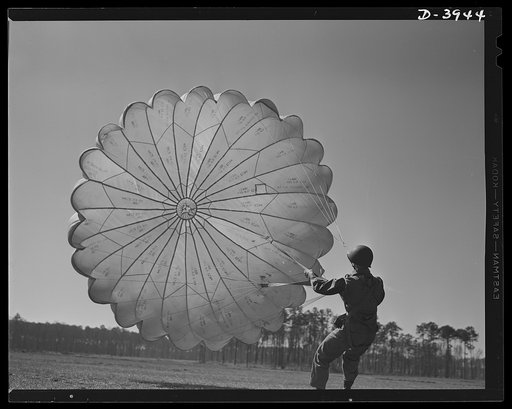 Fort Benning. Parachute troops. Picture of a man doing a good job. He's one of Uncle Sam's student paratroopers at Fort Benning, Georgia, but the way he's getting his chute under contol would do credit to an old timer. A few minutes ago this man bailed out of a high-speed plane at a point calculated