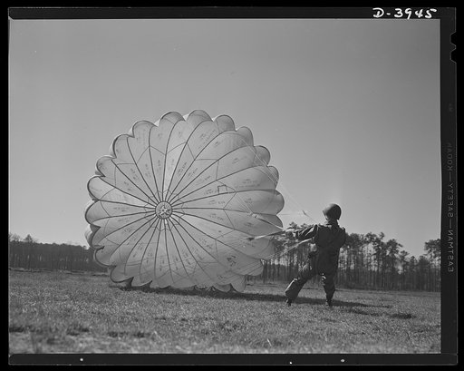 Fort Benning. Parachute troops. Picture of a man doing a good job. He's one of Uncle Sam's student paratroopers at Fort Benning, Georgia, but the way he's getting his chute under contol would do credit to an old timer. A few minutes ago this man bailed out of a high-speed plane at a point calculated