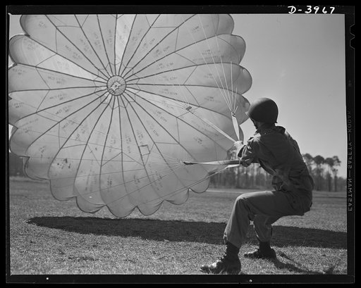Fort Benning. Parachute troops. Picture of a man doing a good job. He's one of Uncle Sam's student paratroopers at Fort Benning, Georgia, but the way he's getting his chute under control would be credit to an oldtimer. A few minutes ago this man bailed out of a high-speed plane at a point calculated