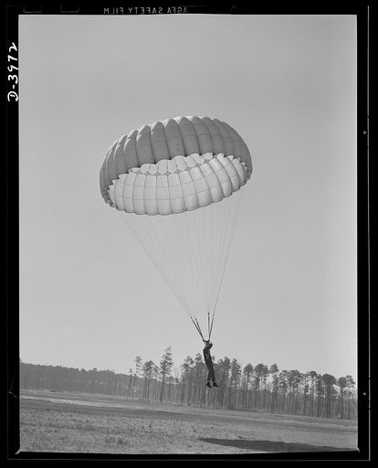 Fort Benning. Parachute troops. Good work! A student paratrooper at Fort Benning, Georgia is about to land in a big, clear space, and he's all set to take the ground in the most approved style