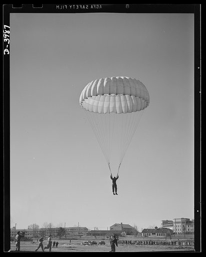 Fort Benning. Parachute troops. Good work! A student paratrooper at Fort Benning, Georgia is about to land in a big clear space and he's all set to take the ground in the most approved paratrooper style