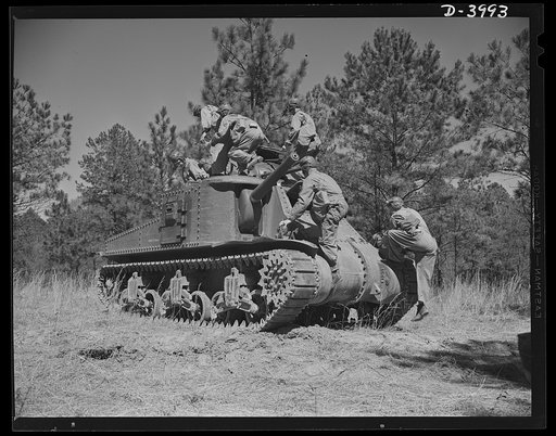 Fort Benning. Tank forces. Crew of a medium tank (M-3) goes aboard. The training course they're finishing at Fort Benning, Georgia has made them smart and proficient soldiers