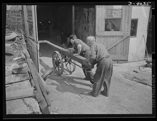 Dr. Bair. College professor and inventor saws steel billets to swell the volume for victory. He and his son use a homemade cart to wheel billets from the unloading point to power saws