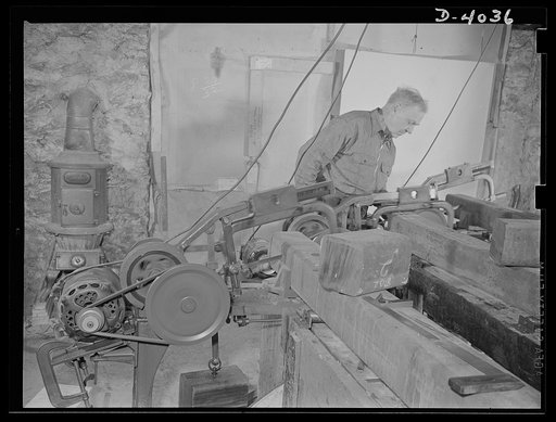 Dr Bair. Scientist becomes workman to aid the War Production Drive. Dr. Bair, holder of eleven college degrees and sixty U.S. patents, saws steel billets on a power hacksaw
