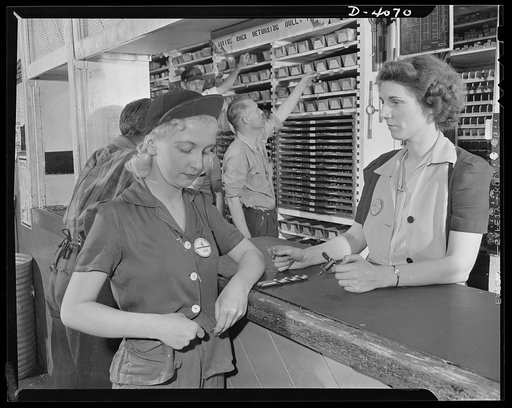 Women aircraft workers. Women work on both sides of the counter at this West Coast aircraft factory. A drill press operator here swaps a tool check for a drill which is given to her by one of the tool crib keepers. Lockhead