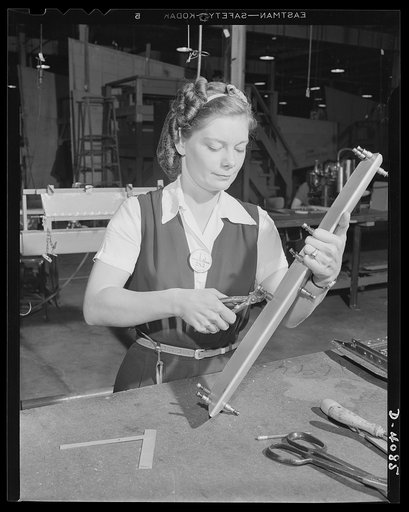 A Pearl Harbor widow gives her complete effort toward defeating the murderers of her husband. Mrs. C. Margaret Bailey starts the assembly of a bomber tail surface trimming tab in a West Coast airplane factory. She has been working here since the first of the year and is glad that this vital work sup