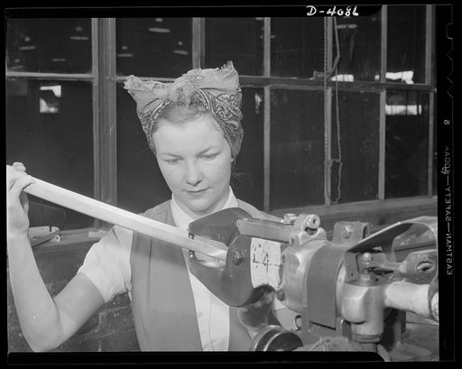 Women aircraft workers. Remember Pearl Harbor? She can't forget it, for Fern Evans's husband was one of America's fighting men who died in action on December 7. Since February, Mrs. Evans has worked for victory at a huge West Coast aircraft plant and is shown here operating a rivet squeezer