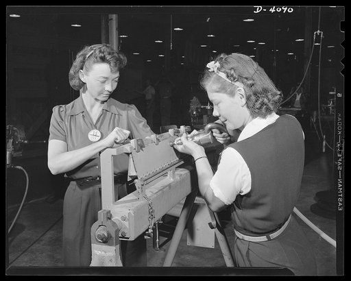 Women aircraft workers. Remember Pearl Harbor? Mrs. Frances Ray Nides (left) and Mrs. C. Margaret Bailey can't forget it, and they're determined that Hitler and Hirohito shall not forget it either. Both are employed at a large West Coast airplane factory and are pictured at work on tail surface trai