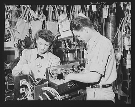 Women aircraft workers. Men and women work together at one of the West Coast's huge aircraft plants. These two are working on an electrical control panel