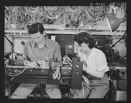 Women aircraft workers. Men and women work together at one of the West Coast's huge aircraft plants. These two are woking on an electrical panel