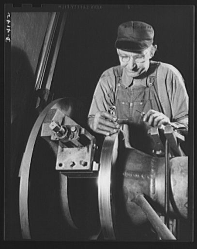 Production. Marine boilers. Machinist facing flange and connector body of a marine steam condensor in a large Midwest plant producing essential equipment for our armed forces