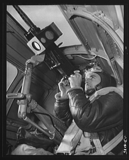 Mitchell Field. An American knight of the air mans the upper gun of one of our new bombers. He, his gun and his plane are typical of the personnel and equipment that have gained world respect for the American Air Force