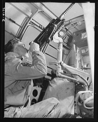 Mitchell Field. An American knight of the air mans the upper gun of one of our new bombers. He, his gun and his plane are typical of the personnel and equipment that have gained world respect for the American Air Force