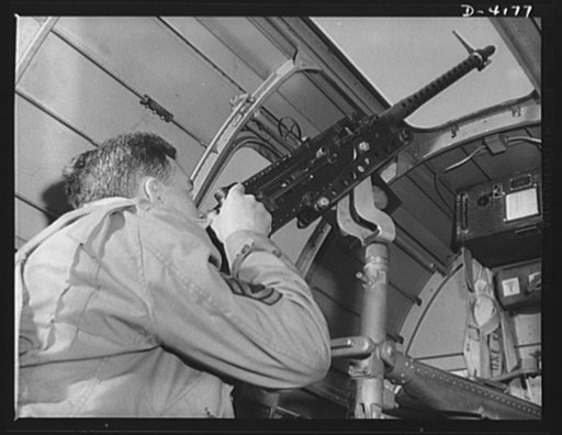 Mitchell Field. An American knight of the air mans the upper gun of one of our new bombers. He, his gun and his plane are typical of the personnel and equipment that have gained world respect for the American Air Force