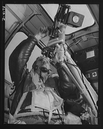 Mitchell Field. An American knight of the air mans the upper gun of one of our new bombers. He, his gun and his plane are typical of the personnel and equipment that have gained world respect for the American Air Force