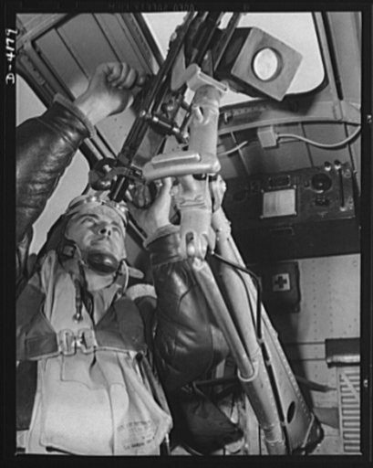 Mitchell Field. An American knight of the air mans the upper gun of one of our new bombers. He, his gun and his plane are typical of the personnel and equipment that have gained world respect for the American Air Force