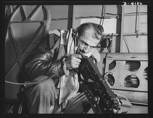 Mitchell Field. Bad news for the Axis when the rear-belly turret gun of an American bomber speaks its piece. The air crew officer at the gun is equipped for any emergency of flight or combat
