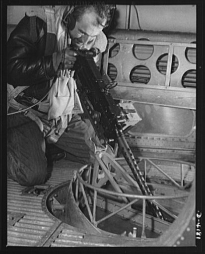 Mitchell Field. Bad news for the Axis when the rear-belly turret gun of an American bomber speaks its piece. The air crew officer at the gun is equipped for any emergency of flight or combat