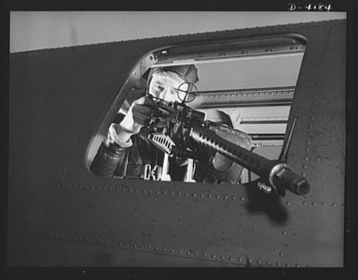 Mitchell Field. Operating the side gun of an American bomber. The Axis view is often very fleeting, for the gun is fast and accurate, and the gunner brave, quick-witted and resourceful