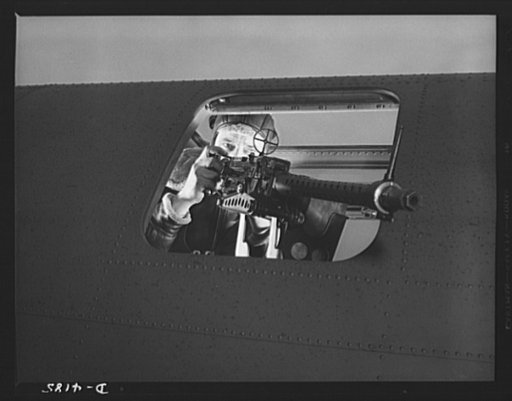 Mitchell Field. Operating the side gun of an American bomber. The Axis view is often very fleeting, for the gun is fast and accurate, and the gunner brave, quick-witted and resourceful