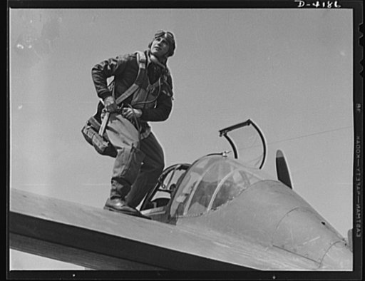 Mitchell Field. Eagle poised for flight. An American pursuit pilot buckles on his parachute just before the takeoff