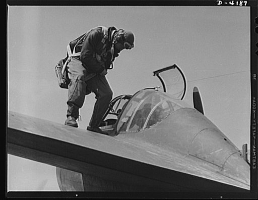 Mitchell Field. Eagle poised for flight. An American pursuit pilot makes the final adjustment of his parachute just before the takeoff