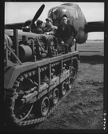 Mitchell Field. An airdrome tractor and its capable crew have no difficulty moving the largest aircraft