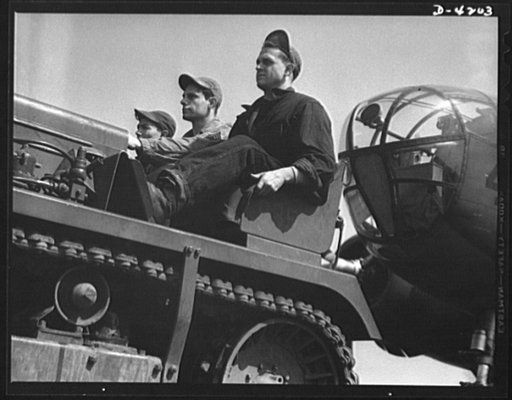 Mitchell Field. An airdrome tractor and its capable crew have no difficulty moving the largest aircraft