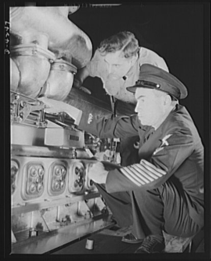 Production. Diesel engines. A diesel engine produced for the Navy at a Midwest manufacturing plant, is inspected by a "five strip" chief petty officer