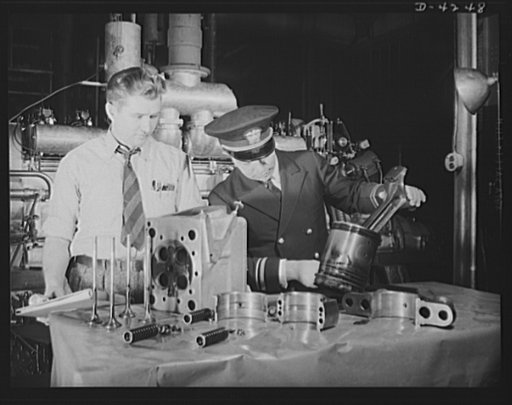 Production. Diesel engines. Naval lieutenant makes a final official inspection of diesel engine parts that have undergone several hours testing in a Midwest manufacturing plant