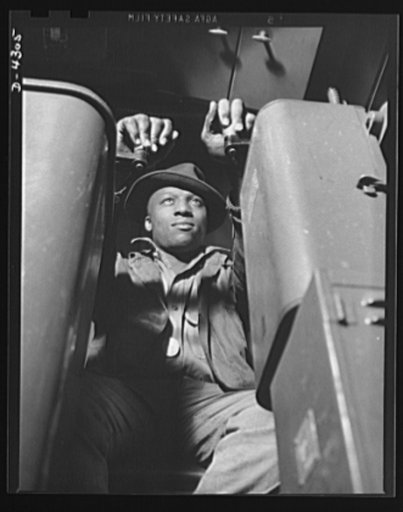 Production. Milling machines and machine castings. Seated in the cab of a monorail crane, this workman shuttles back and forth between the charge make-up pit and the charging doors of the cupolas, three stories above ground. Location: a large Midwest machine tool plant