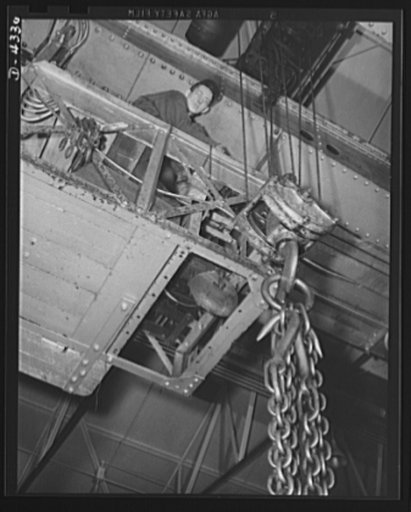 Production. Milling machines and machine castings. Cock of the catwalk -- the crane operator peers down from dozens of feet above the manufacturing floor and hurries over to do any of the heavy lifting and shifting required in the complicated manufacture of machine tools