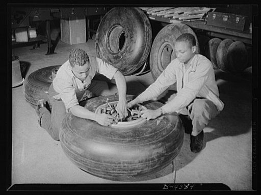 Manpower. Negro bomber plant workers. Conservation of rubber by American motorists makes possible these bomber tires, which are being assembled in a large Eastern aircraft plant. These Negro workers are clamping on lock washers to the wheels before final assembly of the landing gear. Glenn L. Martin