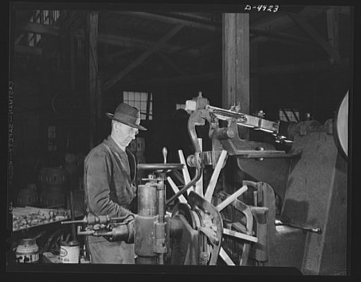 Production. Wagon wheels. Wagon wheels in the making. This operator of a Southern wagon plant is fitting spokes to the hub assembly with the aid of this machine