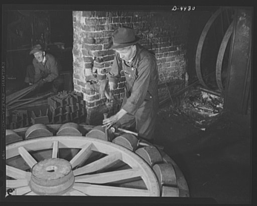 Production. Wagon wheels. Revival of a dying art. Fitting the steel tire to the wagon wheel assembly in the plant of a Southern wagon company which is experiencing a business boom because of the rubber shortage